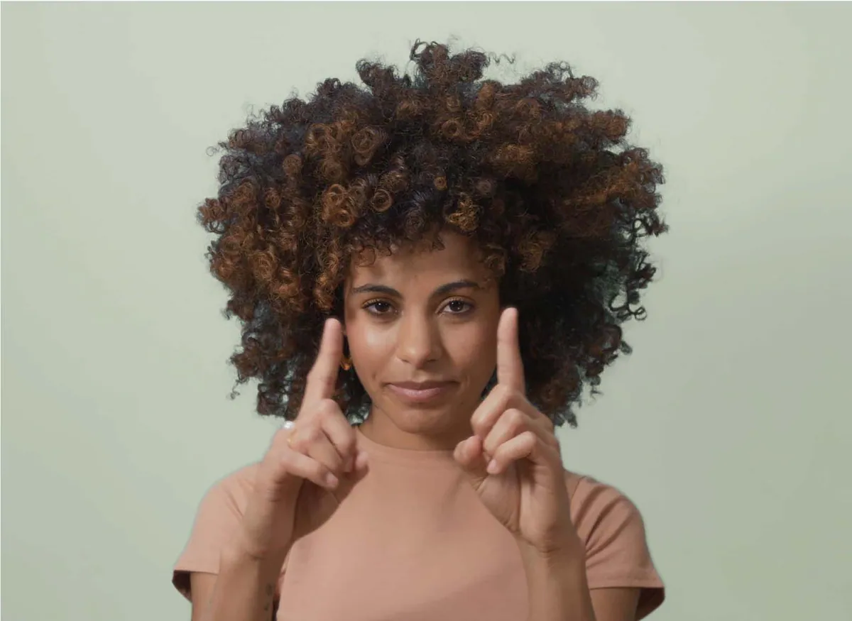 Bathmate campaign photography: a woman making a measuring gesture with her fingers